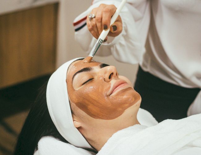 A facial treatment is underway as an esthetician applies a tool to a client&rsquo;s face in a spa.